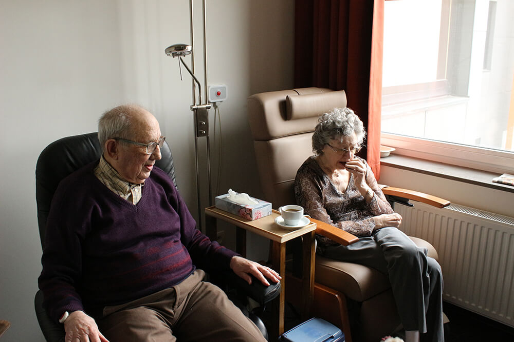 Two seniors sitting in chairs 