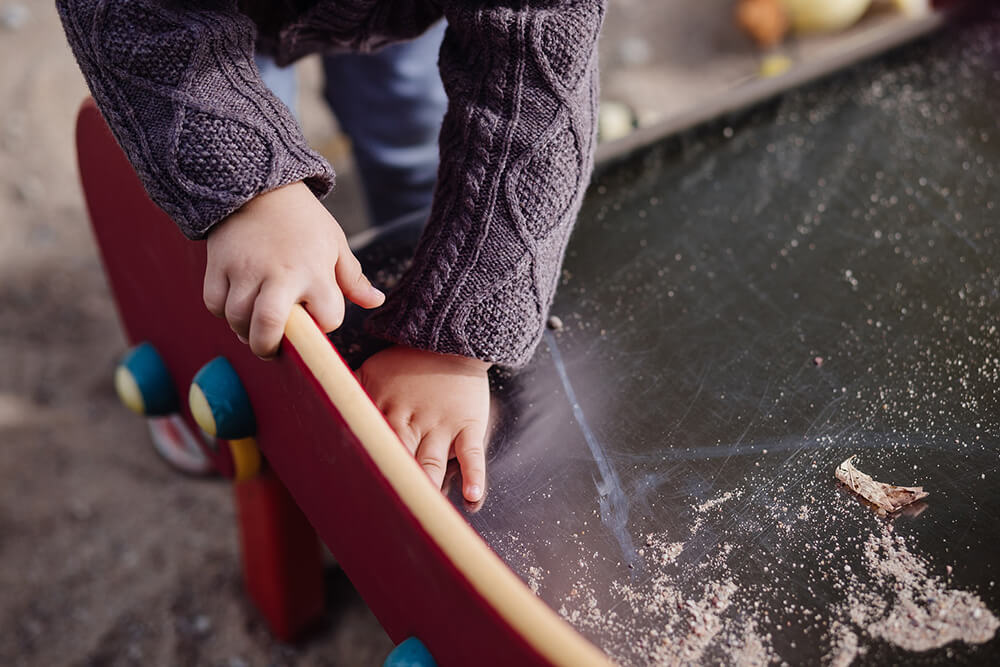 Child leaning on playground equipment