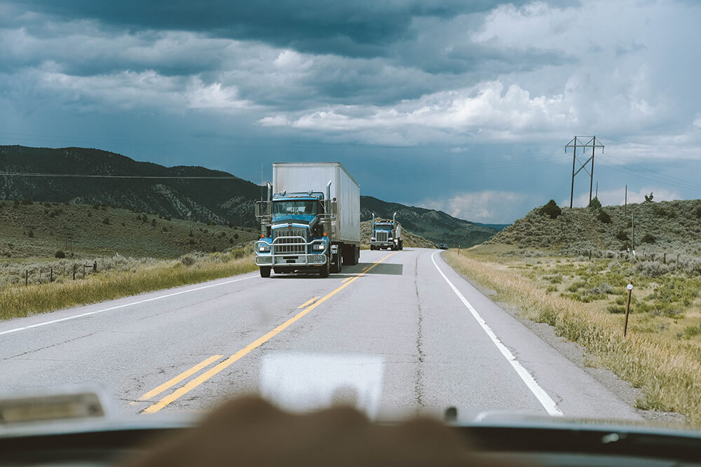 view of truck driving on opposite side of road from windshield